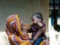 Nepalese vrouw met haar kleinkind op haar schoot            