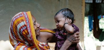 Nepalese vrouw met haar kleinkind op haar schoot                