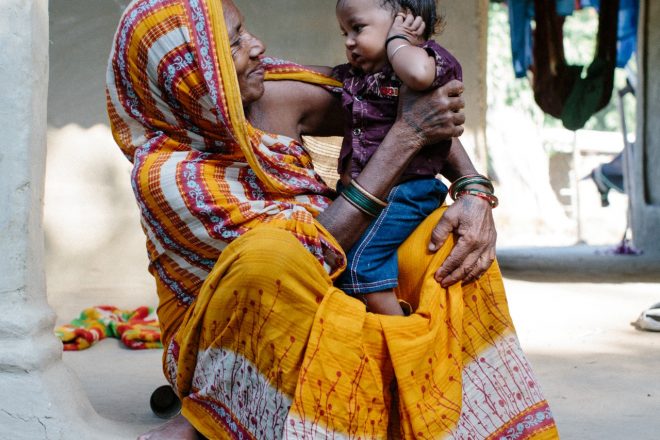 Nepalese vrouw met haar kleinkind op haar schoot