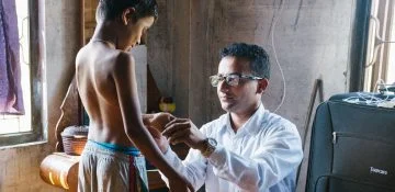 Arts onderzoekt een kind op symptomen van lepra
