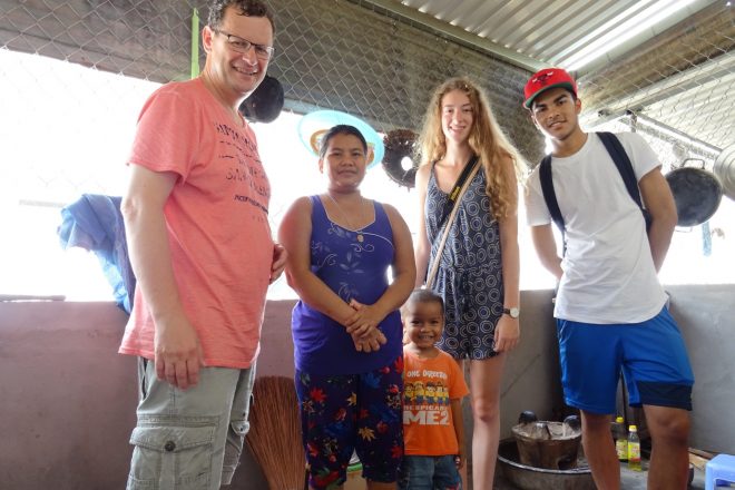 Peter Euser samen met leerlingen in Vietnam op bezoek bij leprapatiënt