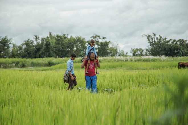 Gopal loopt met zijn kinderen door de rijstvelden