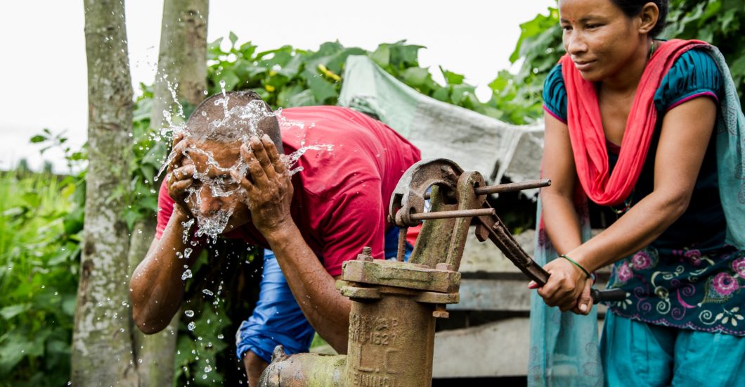 Gopal samen met zijn vrouw bij de waterpomp