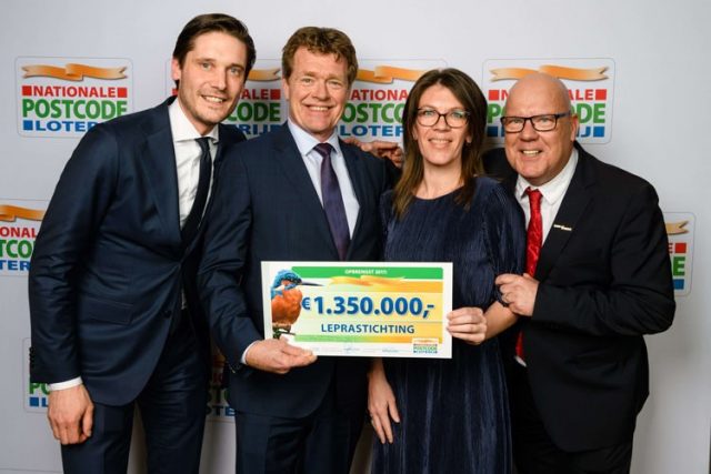 De Leprastichting neemt de cheque van de Nationale Postcode Loterij in ontvangst