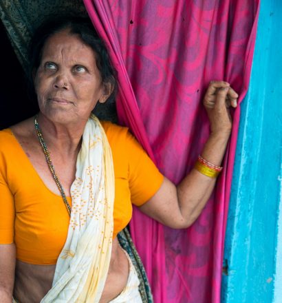Een vrouw uit India staat tegen haar deurpost geleund